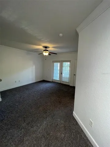 a view of a livingroom with a ceiling fan a ceiling fan and a window