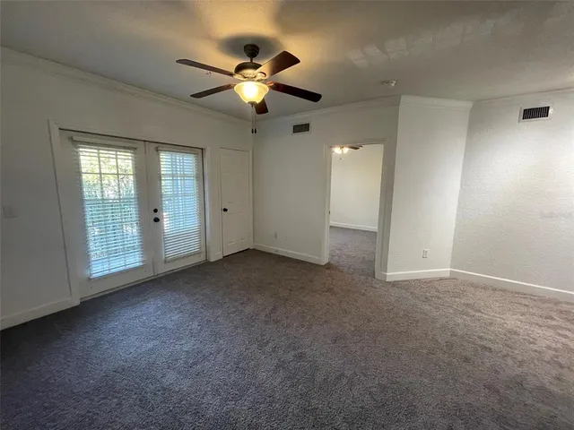 an empty room with windows and fan