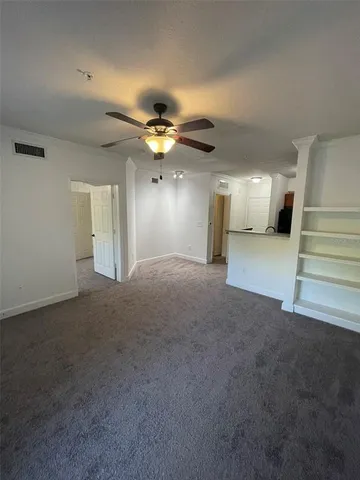 an empty room with windows and fan