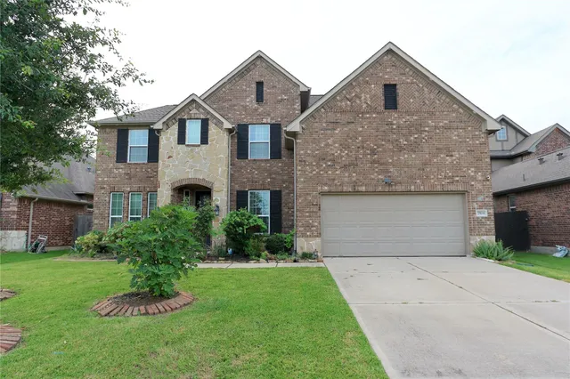 a front view of a house with a garden and garage