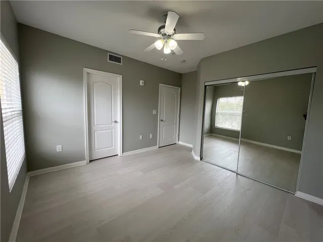 an empty room with fan and entrance
