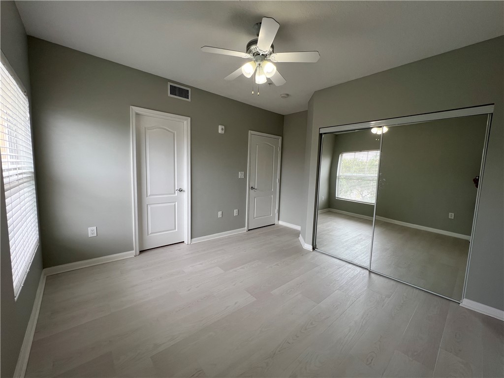 5090 Fairways Circle, Unit H308 Vero Beach, FL 32967 - Photo 16 of 19 an empty room with a chandelier fan and windows