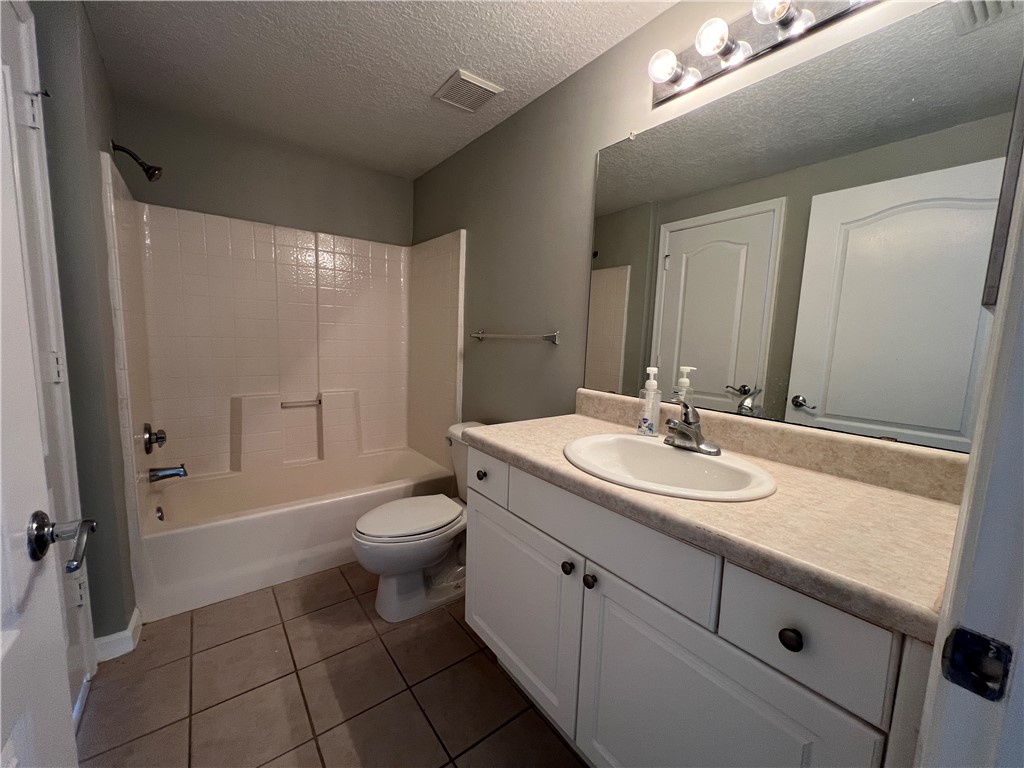 5090 Fairways Circle, Unit H308 Vero Beach, FL 32967 - Photo 18 of 19 a bathroom with a granite countertop sink toilet and shower