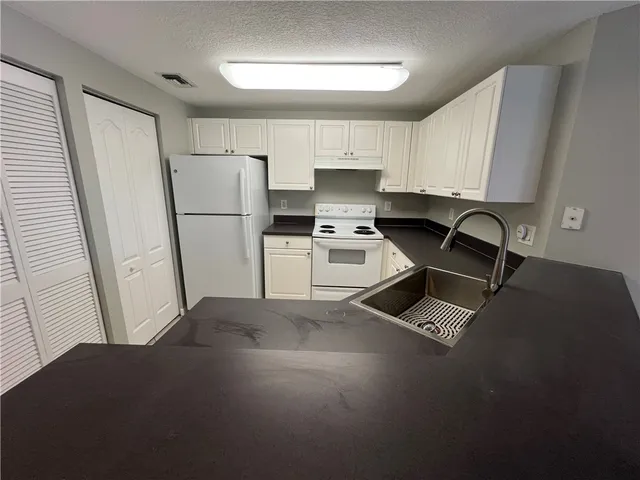 a kitchen with a refrigerator a stove a sink dishwasher and a stove with wooden floor