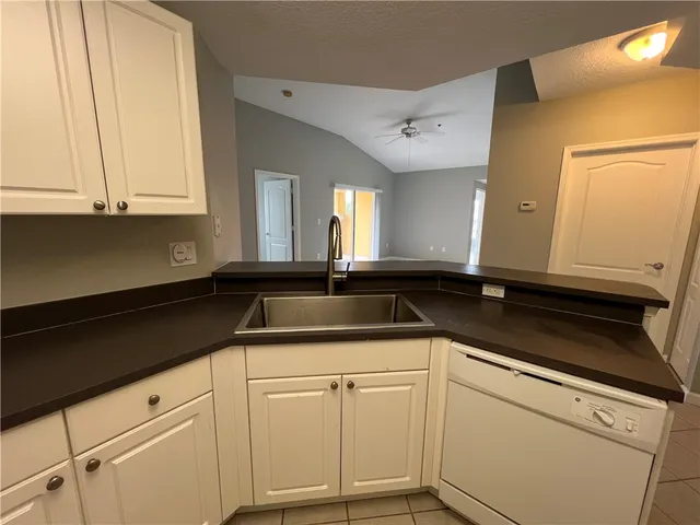 a kitchen with granite countertop white cabinets and white appliances