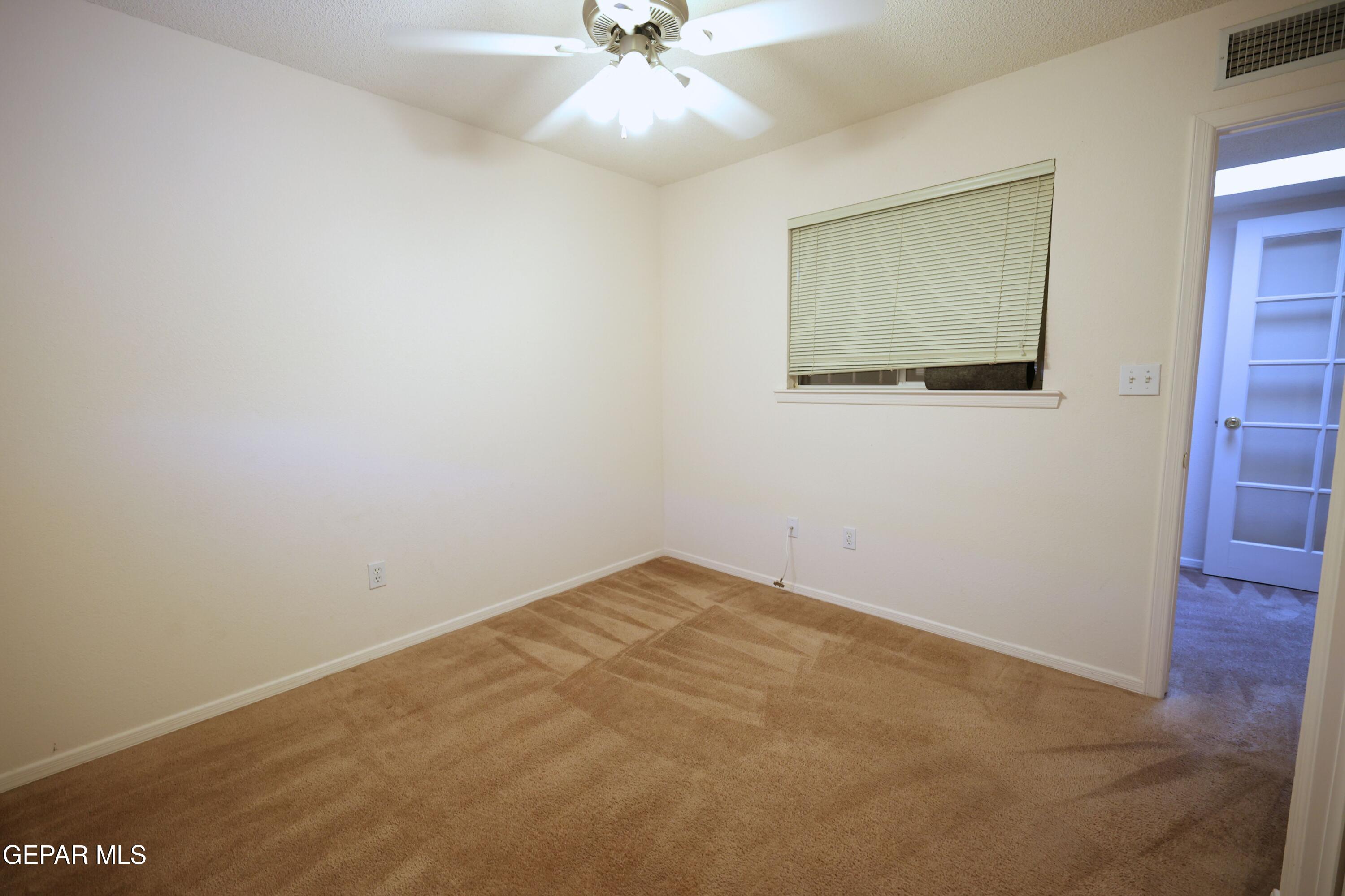 2210 Radford Street El Paso, TX 79903 - Photo 17 of 24 an empty room with a ceiling fan and a window