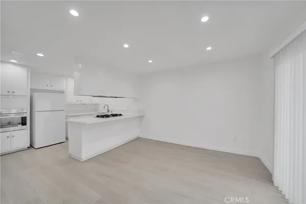 a large kitchen with white cabinets and white appliances