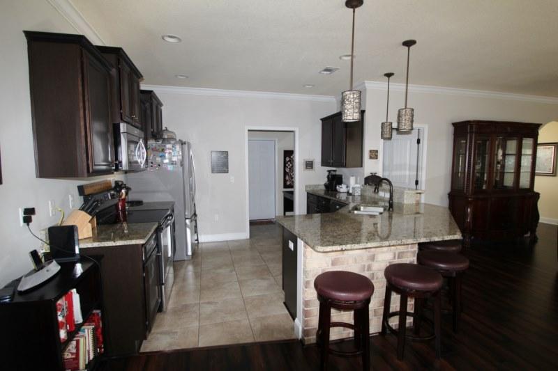4556 Hermosa Road Crestview, FL 32539 - Photo 11 of 35 a view of a dining room with furniture and wooden floor