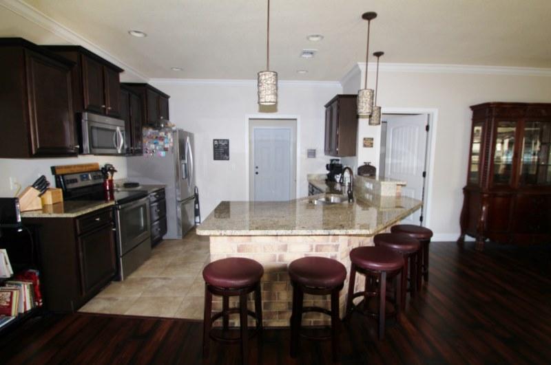 4556 Hermosa Road Crestview, FL 32539 - Photo 4 of 35 a kitchen with stainless steel appliances kitchen island granite countertop a sink and cabinets