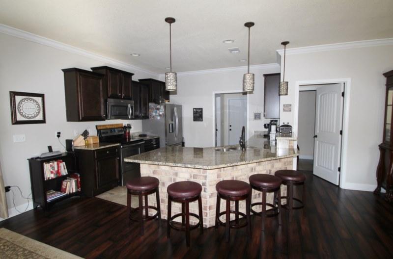 4556 Hermosa Road Crestview, FL 32539 - Photo 34 of 35 a kitchen with stainless steel appliances kitchen island granite countertop a table chairs and a refrigerator