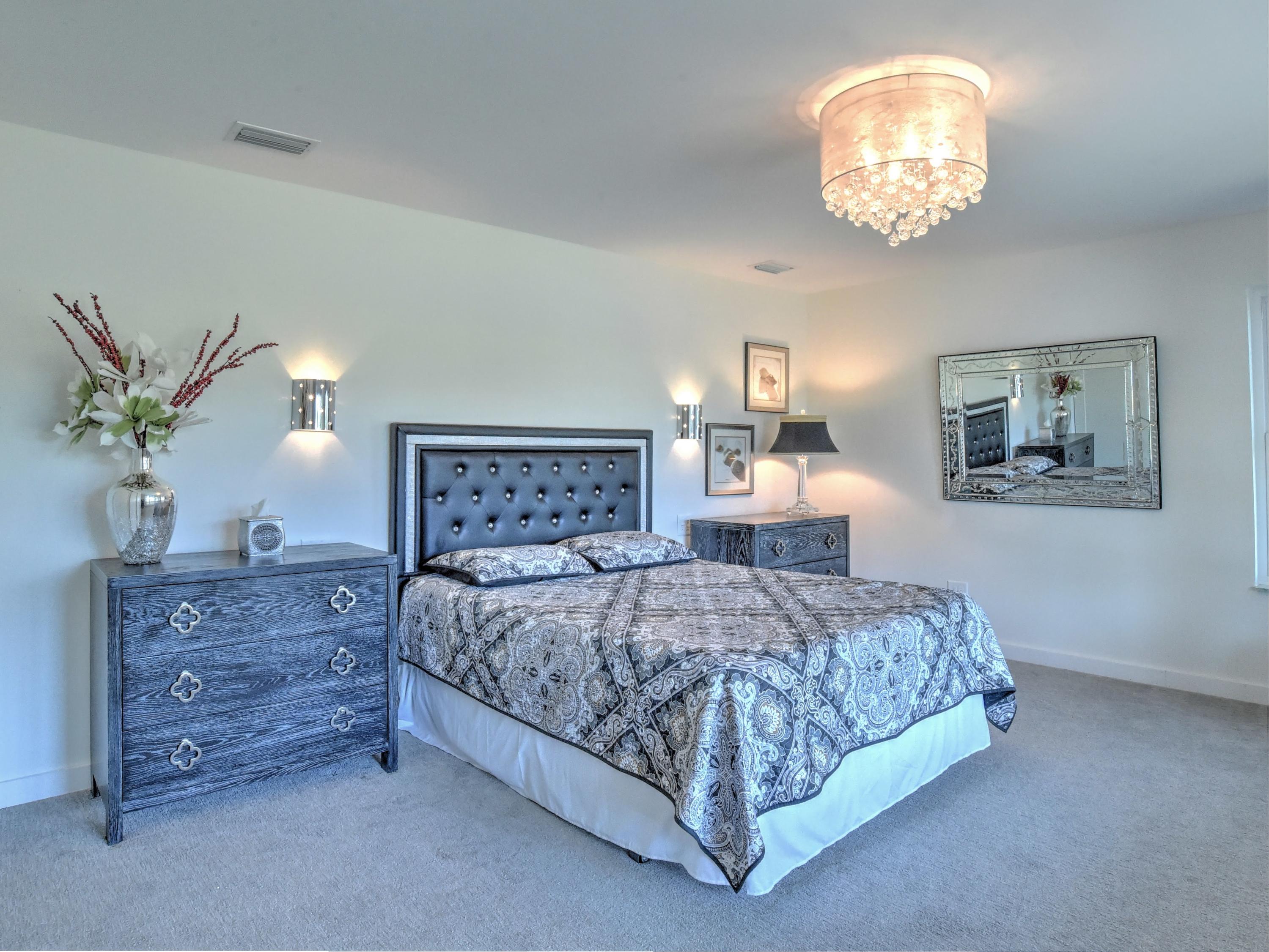 95 Bayou Road Santa Rosa Beach, FL 32459 - Photo 45 of 70 a bedroom with a large bed and a chandelier
