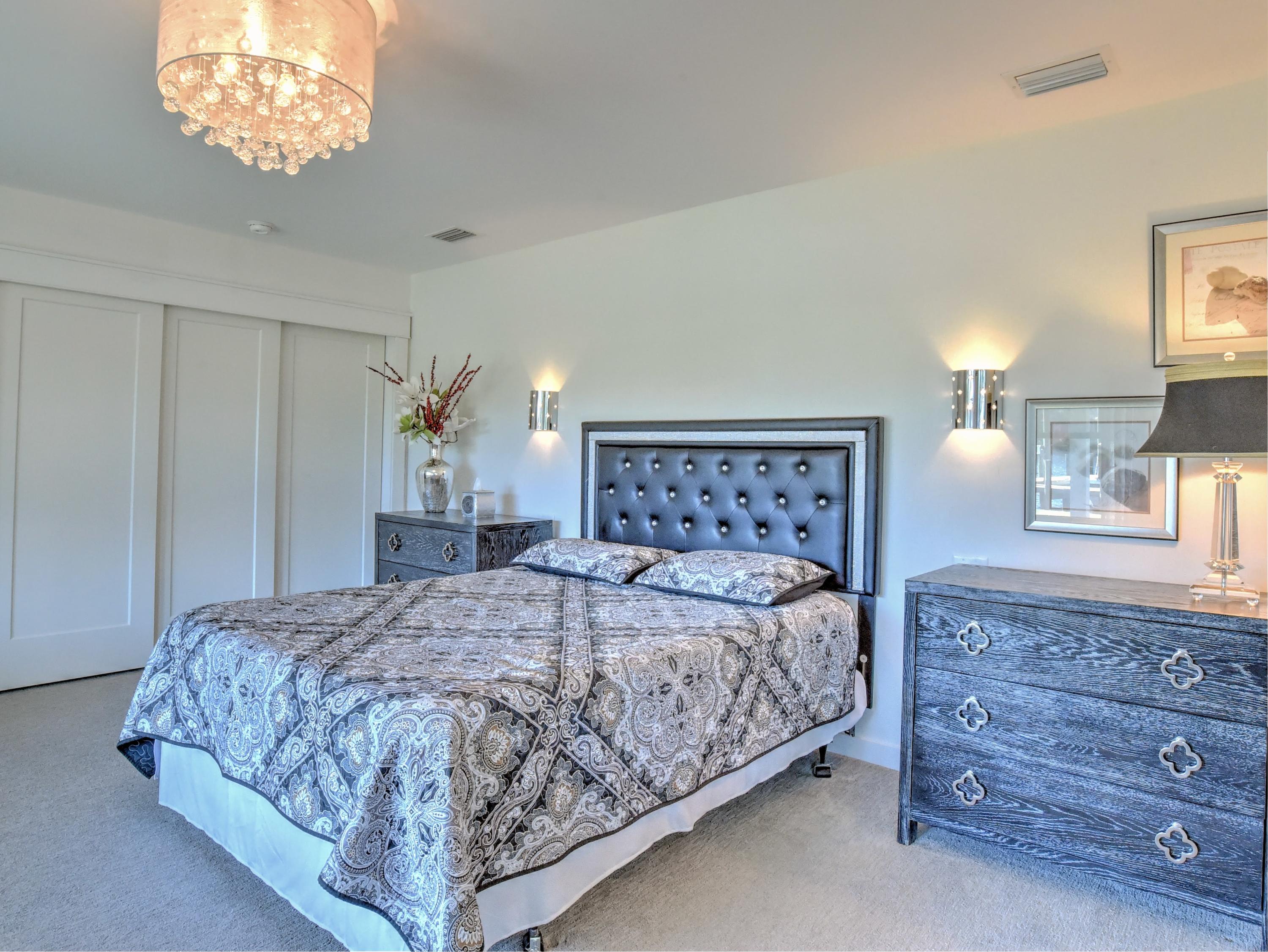 95 Bayou Road Santa Rosa Beach, FL 32459 - Photo 46 of 70 a bedroom with a large bed and a chandelier