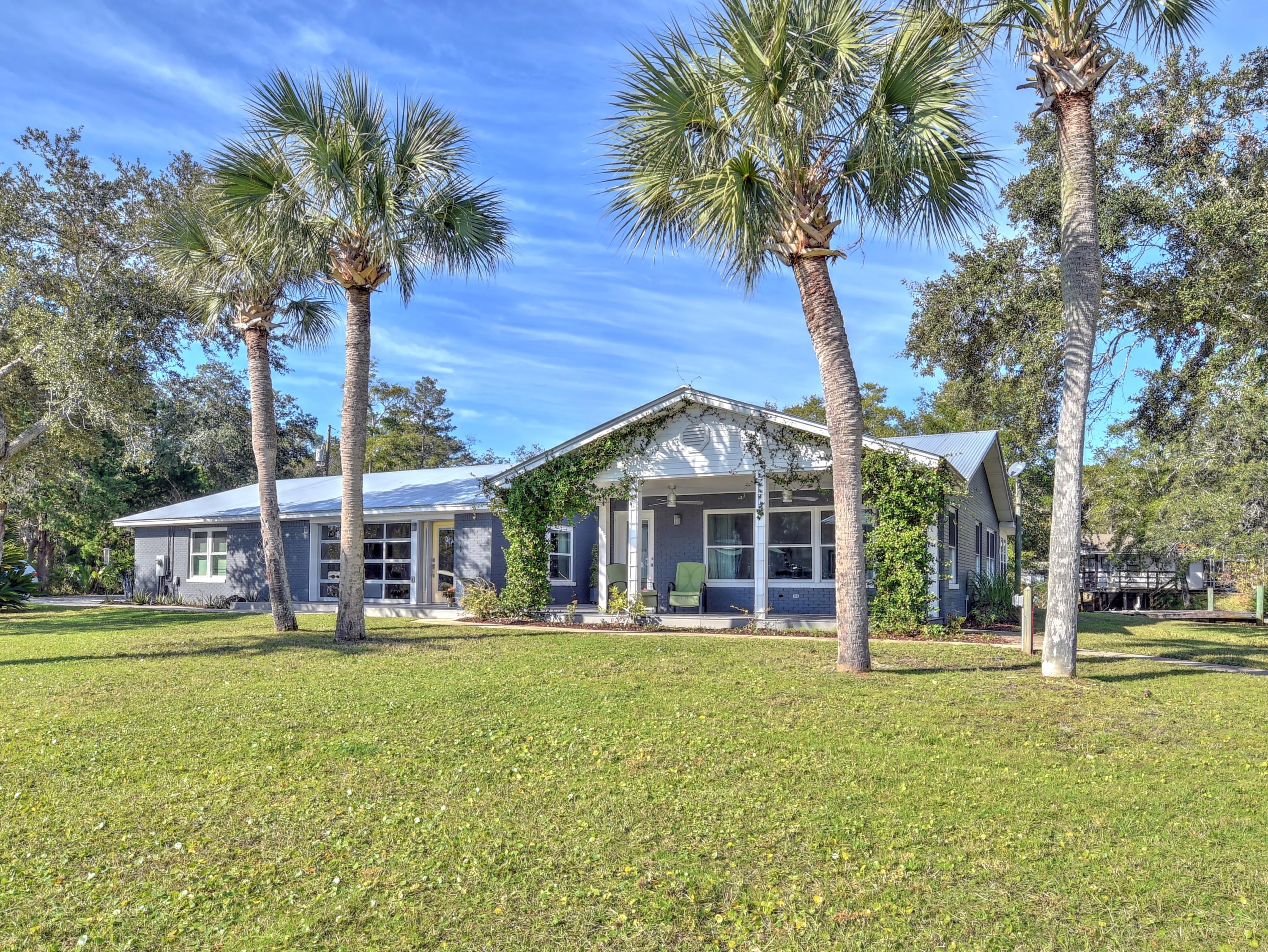 95 Bayou Road Santa Rosa Beach, FL 32459 - Photo 53 of 70 a front view of a house with a yard table and chairs