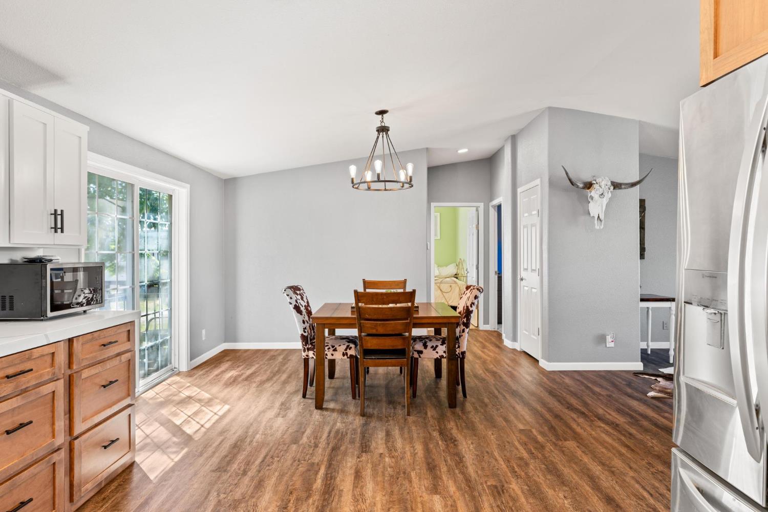 12518 Lone Oak Road Waterford, CA 95386 - Photo 17 of 50 a view of a dining room with furniture window and wooden floor