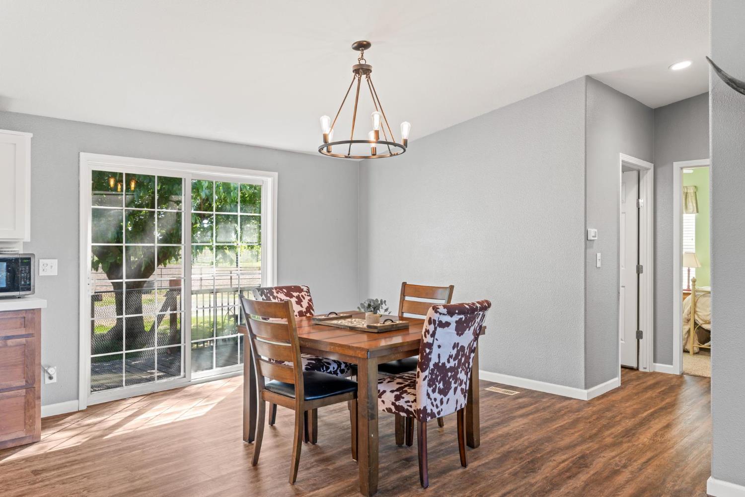 12518 Lone Oak Road Waterford, CA 95386 - Photo 18 of 50 a view of a dining room with furniture window and wooden floor