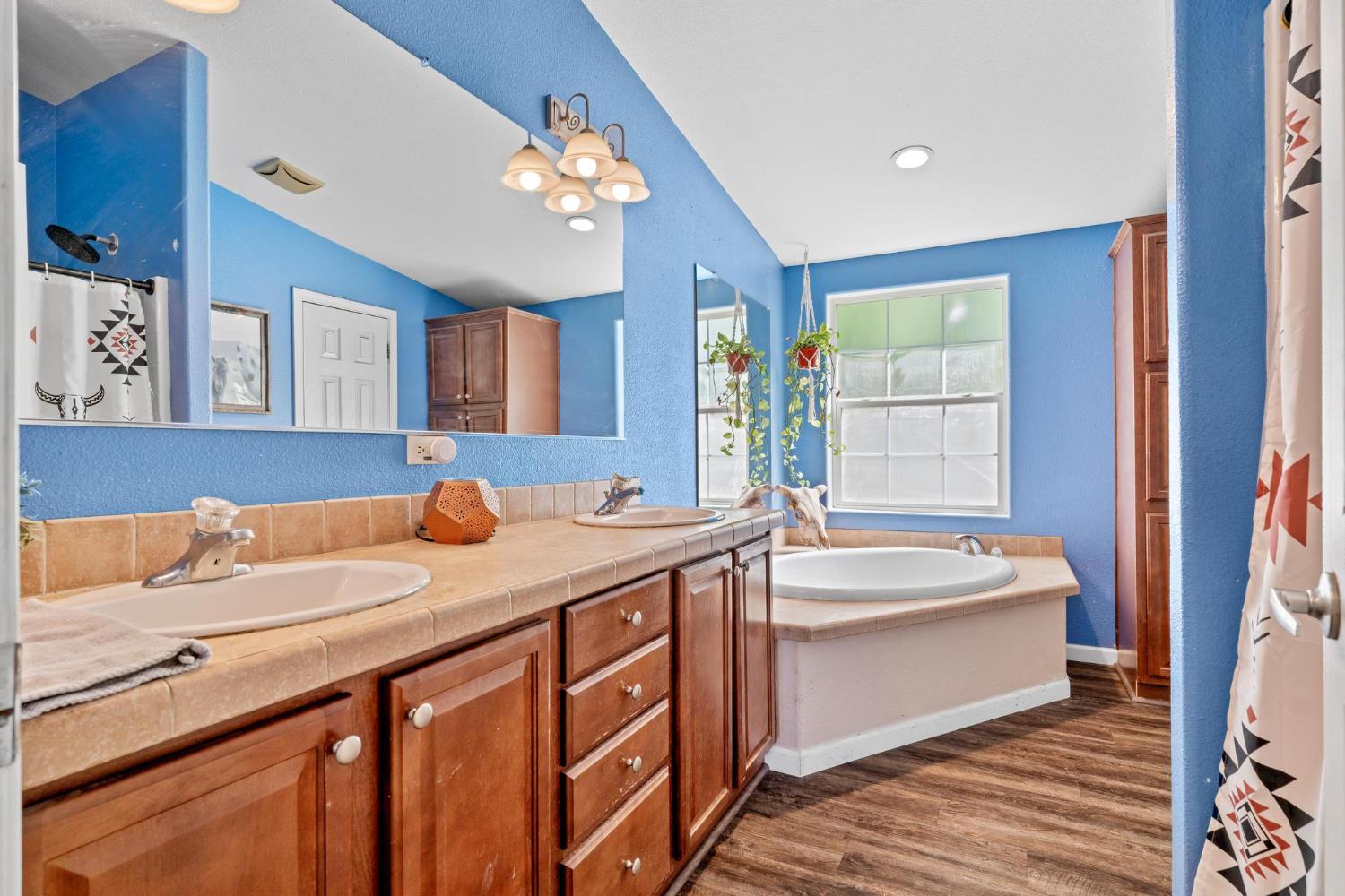 12518 Lone Oak Road Waterford, CA 95386 - Photo 21 of 50 a bathroom with a sink double vanity granite tub and a large mirror