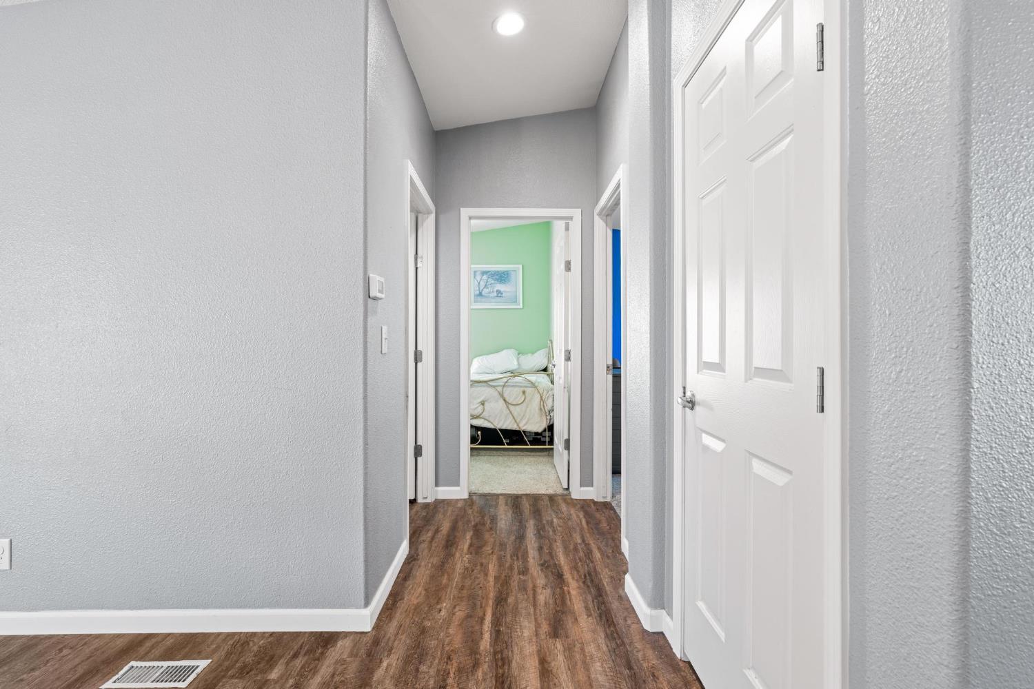 12518 Lone Oak Road Waterford, CA 95386 - Photo 23 of 50 a view of a hallway with wooden floor and a bedroom