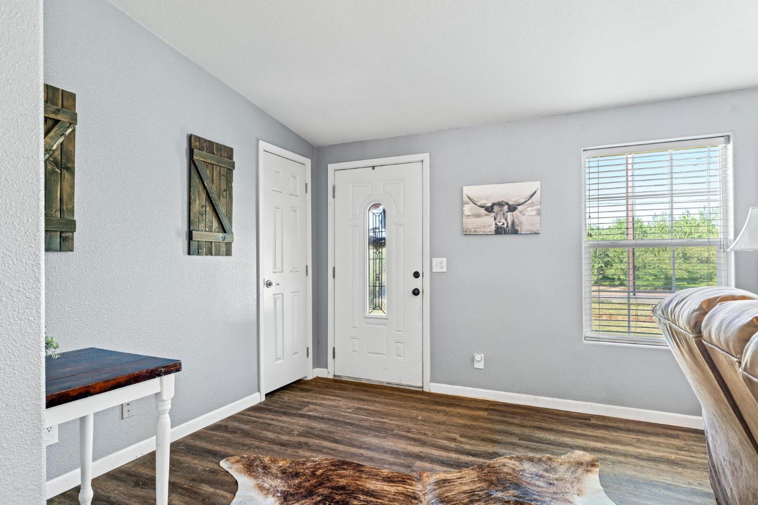 12518 Lone Oak Road Waterford, CA 95386 - Photo 9 of 50 a view of an empty room with wooden floor and a window