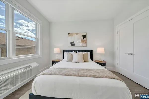 a large bed sitting in a bedroom next to a window