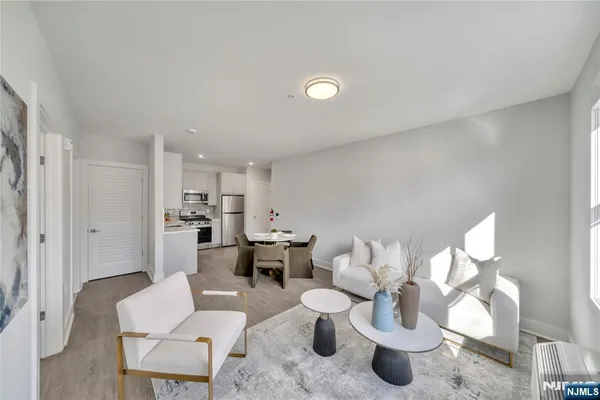 a living room with furniture and a dining table with kitchen view