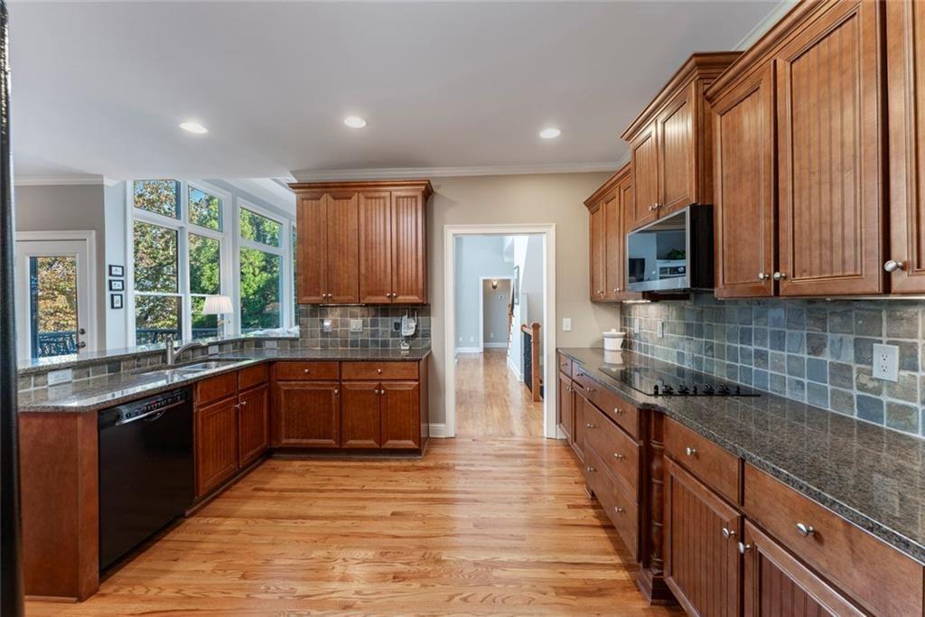 300 Tupelo Trail Canton, GA 30114 - Photo 14 of 50 a large kitchen with stainless steel appliances granite countertop a stove top oven a sink dishwasher a dining table and chairs with wooden floor