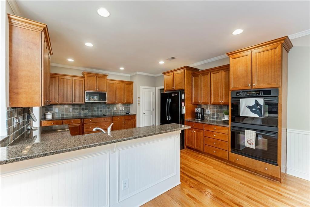 300 Tupelo Trail Canton, GA 30114 - Photo 17 of 50 a kitchen with stainless steel appliances granite countertop a stove a sink and a microwave