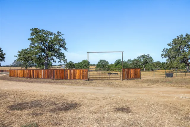 a view of backyard with potted plants and wooden fence