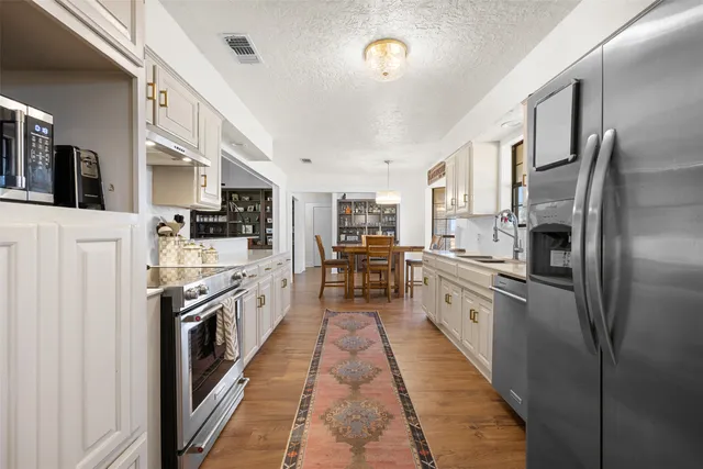 a large kitchen with stainless steel appliances lots of counter space sink and a large window