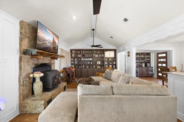a living room with furniture a flat screen tv and a fireplace