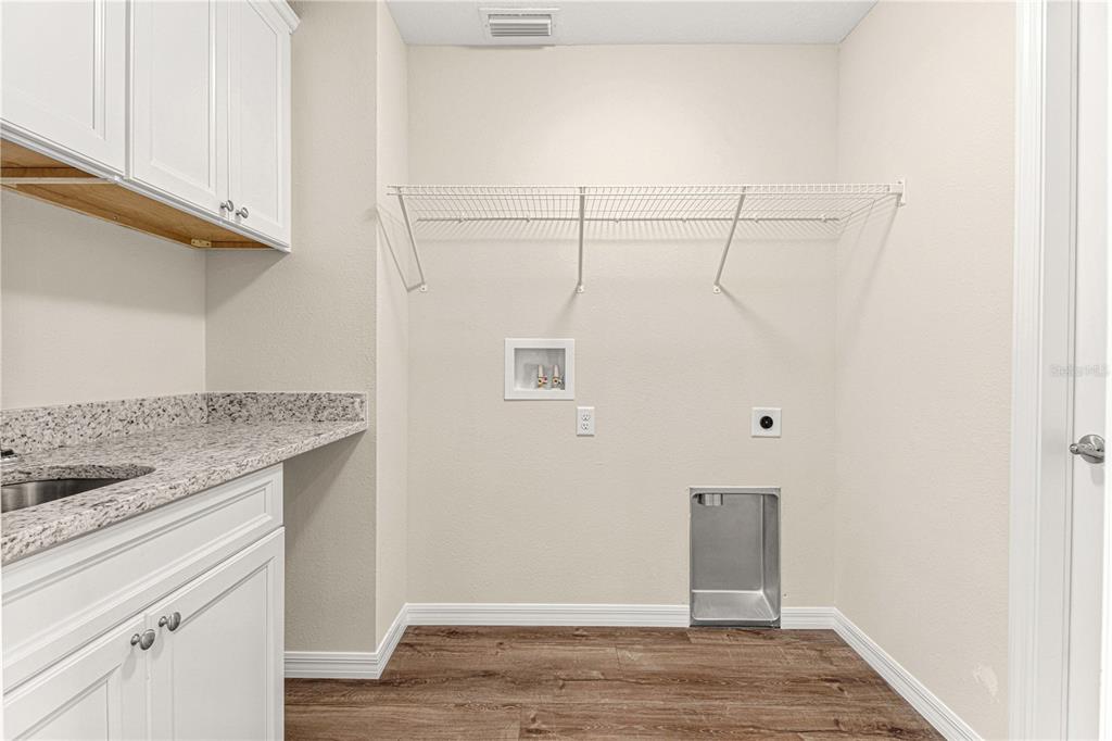 15189 56th Terrace Road Ocala, FL 34473 - Photo 25 of 28 Laundry room with cabinets, granite laundry folding bar and sink