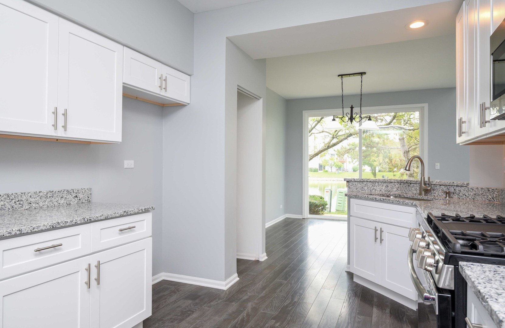 1032 Ripple Ridge, Unit 19 Darien, IL 60561 - Photo 7 of 28 a kitchen with granite countertop wooden floors and white appliances