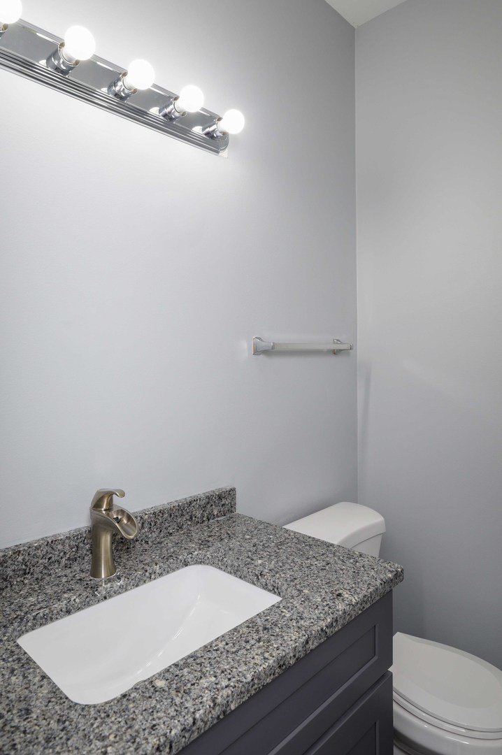 1032 Ripple Ridge, Unit 19 Darien, IL 60561 - Photo 10 of 28 a bathroom with a granite countertop sink and a toilet