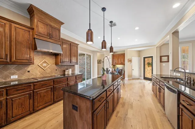 a kitchen with granite countertop a sink a counter space appliances and cabinets