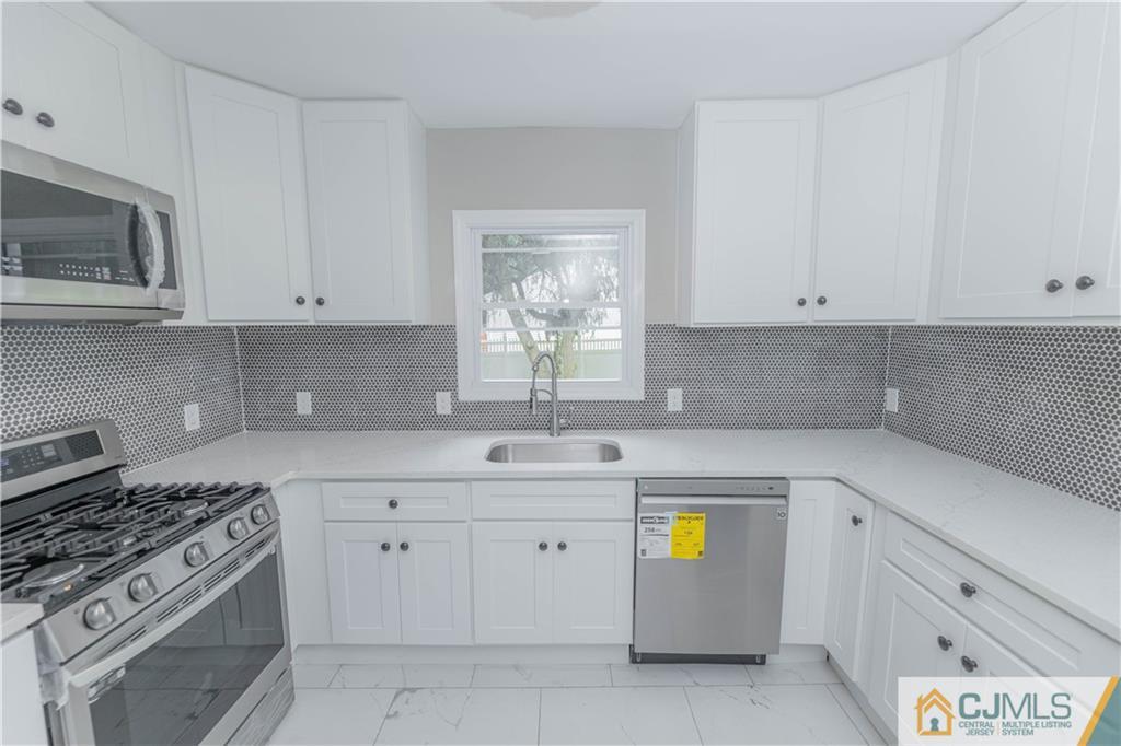 a kitchen with cabinets appliances and a window