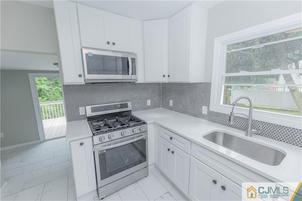 7 North Shore Boulevard Helmetta, NJ 08828 - Photo 4 of 50 a kitchen with granite countertop a sink stainless steel appliances and cabinets