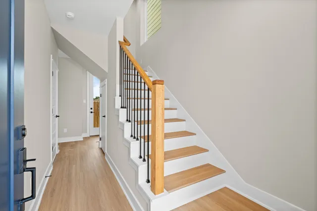 a view of a hallway with wooden floor and staircase