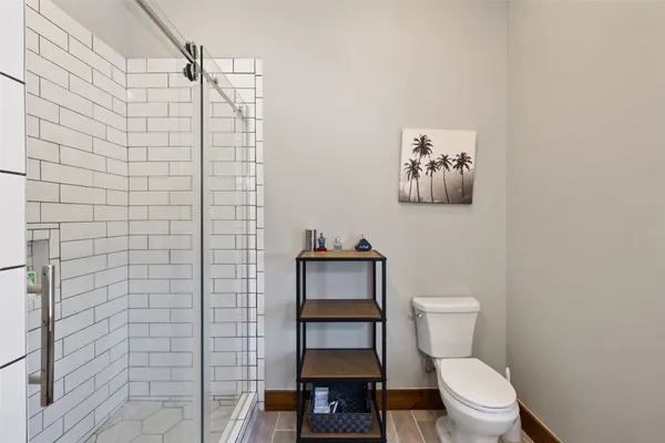 a bathroom with a toilet and a shower