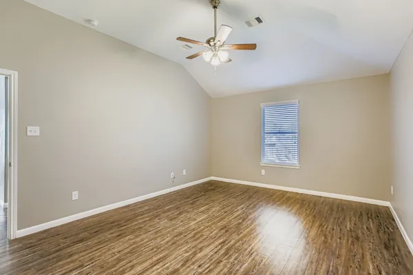 a view of a room with wooden floor and a ceiling fan