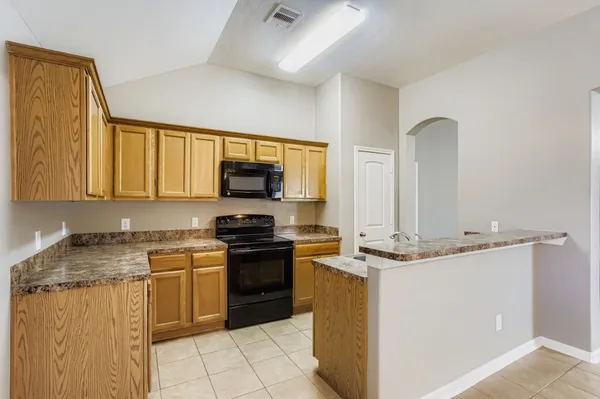 a kitchen with stainless steel appliances granite countertop a stove a sink and a microwave