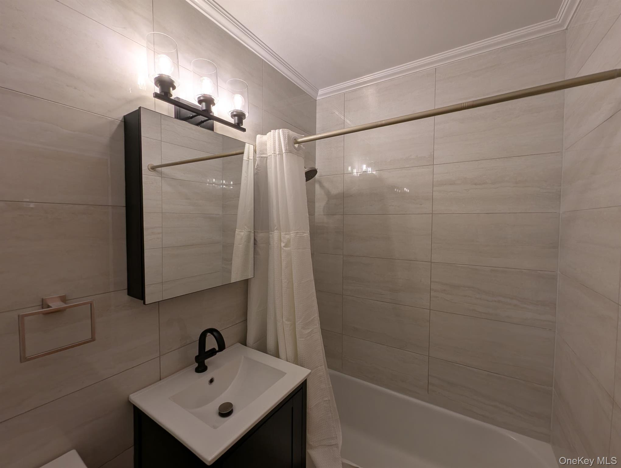 64-34 102nd Street, Unit 7F Queens, NY 11374 - Photo 11 of 17 a bathroom with a sink mirror and shower