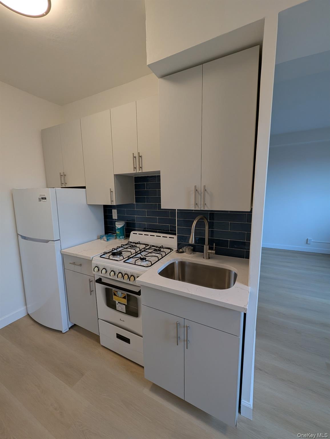 64-34 102nd Street, Unit 7F Queens, NY 11374 - Photo 7 of 17 a kitchen with a stove and a refrigerator