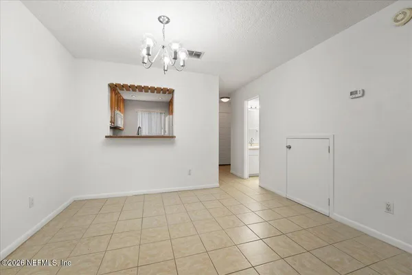 an empty room with kitchen view