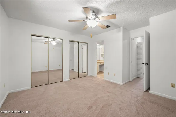an empty room with closet and fan