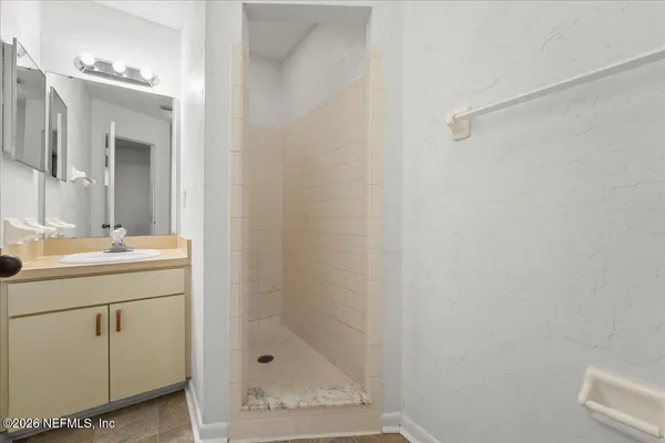 a bathroom with a shower sink and mirror