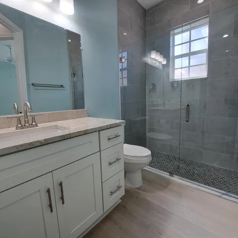 a bathroom with a granite countertop sink toilet and shower