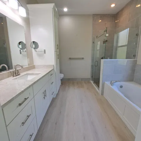 a bathroom with a double vanity sink a mirror and a bathtub
