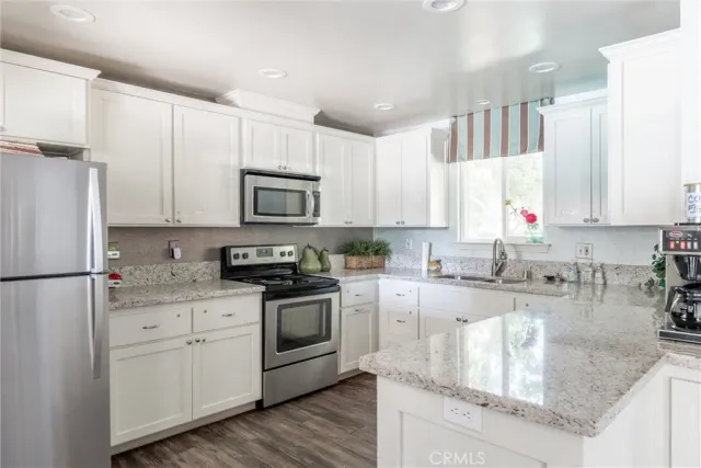a kitchen with stainless steel appliances granite countertop a refrigerator sink and stove