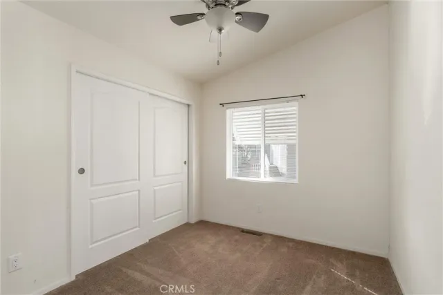an empty room with a window and a ceiling fan