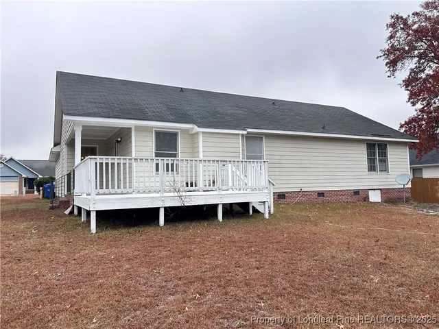 a backyard of a house with a wooden deck and barbeque oven