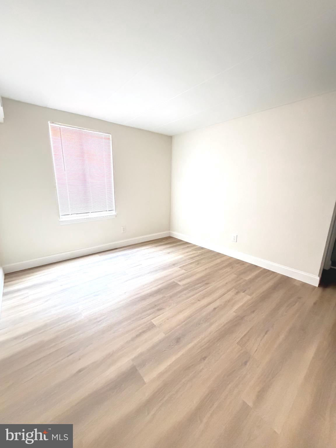 2316 Freetown Court, Unit 1B Reston, VA 20191 - Photo 33 of 36 an empty room with wooden floor and windows
